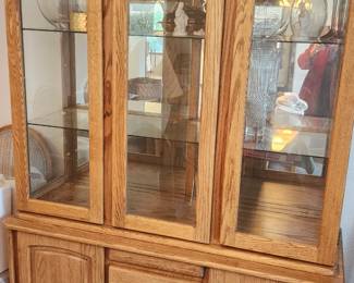 Sold Oak Two-Piece China Cabinet with Glass Doors and Lighting. 