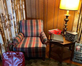 Armchair, tall vintage brass lamp, side table with cane weave bottom shelf.