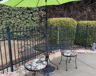 Wrought iron round bistro table with 2 chairs and cushion. Umbrella with stand.