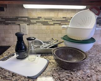 Kitchen Prep & Utility Collection
• Mixing & Serving: Two speckled nesting bowls, a large white lidded mixing bowl, and two white plastic colanders.
• Food Prep Tools: A KitchenAid manual food chopper, a clear glass carafe, a white cutting board, and various stainless steel utensils (tongs, mesh strainer).
&nbsp;
&nbsp;