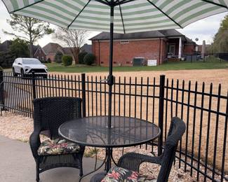 Wrought iron outdoor round table with two chairs and cushions. Umbrella and stand included.
