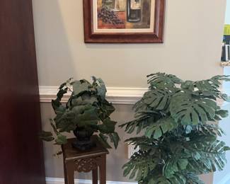 Vineyard Vibe Decor: Wine Art & Faux Greenery
• Wine Still Life Art: Framed print featuring wine bottle, glasses, and grapes. 21x 25
• Large Faux Monstera: Tropical artificial plant in a woven basket with metal stand.14d14w41h
• Pedestal Side Table: Slim wood-finish stand with decorative scrollwork.10x23h&nbsp;
• Potted Faux Ivy: Artificial ivy arrangement in a dark urn-style planter.
Framed wall art of kitchen herbs.

Framed oil of grapes
