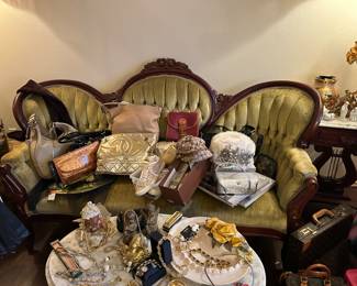 Victorian style loveseat with many designer purses and accessories 