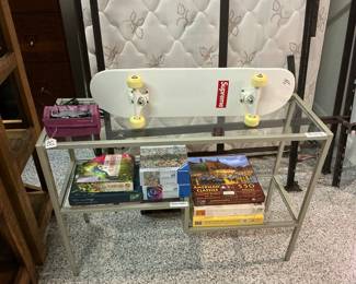 Modern glass and metal frame hall table. Supreme collector’s skate board. Puzzles. Small, portable set of hot curlers great for travel. 