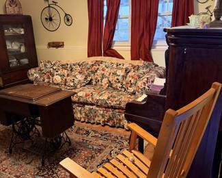 Couch/Sofa, rocking chair, piano, antique china cabinet, antique Singer sewing machine, area rug, wall decor.