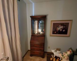 Vintage lamp in foreground. Secretary and many charming items.