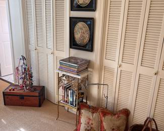 Framed silk embroidery, small brass table, small antique wooden trunk, beaded footstool, pillows, basket, books