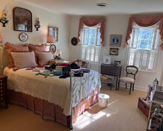 Antique iron bed with linens, bed skirt, and window treatments, framed antique needlepoints, Staffordshire, sconces