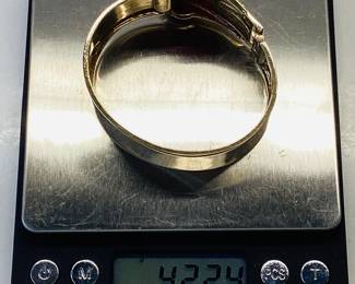 14K BUCKLE BANGLE WITH OVER 3 CTW OF RUBIES 42.2G THIS DESIGNER BUCKLE BANGLE FEATURES 26, 12PT PRINCESS CUT RUBIES AND 2, 15PT CABOCHON RUBIES, ONE ON EACH SIDE. THIS PIECE IS GUARANTEED TO TURN HEADS AT EVERY OCCASION. CARAT WEIGHTS ARE APPROPRIATE.