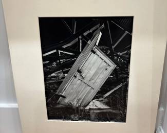 Black and White Photograph of a Collapsed Structure with a Door