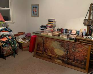 Those are books on the table behind the framed painting.  There  is a chair underneath the bedding.