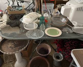 Oval outdoor table, planters and garden items.