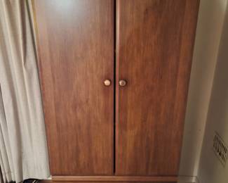 Vintage wood-finish wardrobe armoire with two doors and two drawers.