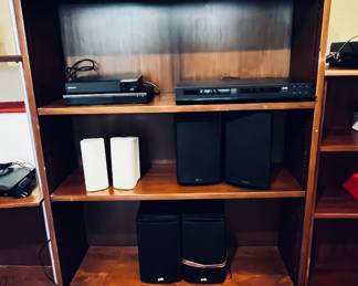 Wooden Shelves with a variety of electronics , speakers, recievrs, dvd player