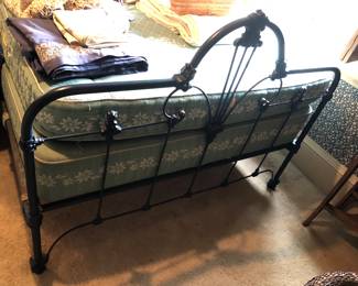 Footboard of blue iron bed (54”W, 40” high at center)