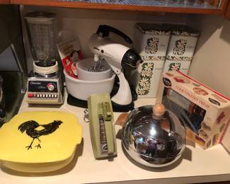 Pyrex yellow Hostess bowl with lid, Osterizer Galaxies blender, Sunbeam Mixmaster stand mixer, Sunbeam avocado hand mixer, Penguin chrome ice bucket, set of 4 Cheinco daisy canisters, Mirro cooky-pastry press - in original box