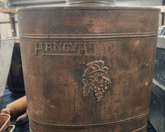 Copper backpack sprayer with a grape motif.