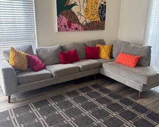 Gray fabric L-shaped sofa with accent pillows. Approximately 9x6 foot