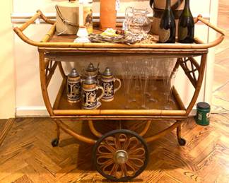 Mid-Century rattan bar cart. Top sheet of veneer needs repair or replacement.