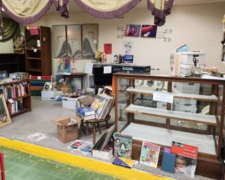 Vintage books, vinyl albums, artwork, antique wood display cabinet with wavy glass, swag curtain