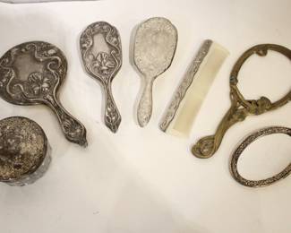 A vintage cut glass powder jar with an ornate silver plated lid 4" x 2", a vintage silver plated handheld mirror with Hibiscus flower 10" x 5", a matching vintage Art Nouveau silver plated vanity brush with Hibiscus flower 8". A vintage silver plated vanity brush with ornate floral and scroll designs 8", with a matching vintage silver plated vanity comb 7.5". An Art Nouveau style hand held golden brass graceful woman 10" x 4.5", and lastly an Art Nouveau brass mirror 5" x 3". 
BUYERS BEWARE no stamp could be found on the silver plated items (the first 5 items) but are strongly  believed to be silver plated.
These items can be shipped.