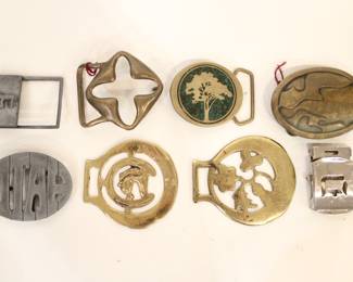 Several designer brass buckles including, a vintage belt buckle featuring the Hebrew Chai symbol. 
vintage 1970s Duncan D. Laurie solid brass modernist "Cross" or "X" abstract belt buckle. 
vintage 1978 BTS brass belt buckle with a tree design and possible turquoise inlay. 
Vintage Derek Marchi Solid Brass Hand Made Belt Buckle
A metal Utah souvenir belt buckle
a vintage horse brass medallion
Vintage Brass Scottish Horse Saddle Bridle Medallion Country
A standard buckle with a "D" design.
These items can be shipped.
