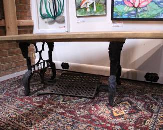 A rustic industrial-style table with a reclaimed wood top and a salvaged cast iron sewing machine base 48" x 20" x 16". This item can not be shipped.