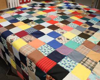 A large handmade quilt featuring many colors and patterns on the top and a teal on the bottom, in excellent condition, 88" x 95". This item can be shipped.