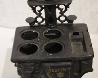 Vintage Crescent cast iron salesman sample stove 4.5" x 5.5", in a lot with, miniature cast iron toy stove 4" x 3.5". A small bucket 6" with a cast iron shovel, 5 miscellaneous accessories, 8 pots and pans, 2 stove top covers, and 3 copper toned pots. These items can be shipped.
