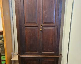 Early 2 piece cherry corner cupboard . unusual cut out shelves.