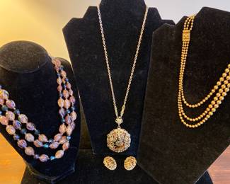 Gold tone necklace and earrings in the center marked “W Germany”. Triple strand multi-color necklace on the left is marked “Korea”