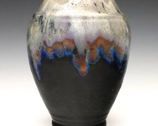 An early 20th century Pewabic Art Pottery vase.  Ovoid form with drip glaze in mottled shades of Iridescent Blue and Pale Green.  Impressed "Pewabic Detroit" mark, also retains original "Pewabic Detroit" medallion paper label at underside.  2 1/2" long hairline at rim, minor surface wear, some crazing.  8" high. 