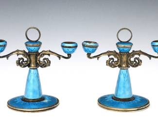 A pair of early 20th century Continental .800 Silver candelabra with enameled guilloche decoration.  Two light design with scrolled arms, Blue enamel with Gilded finish.  Unmarked, tested .800 Silver or higher.  Minor surface wear, a few flakes to enamel.  5.83 troy ozs total.  Each 3 3/4" high.  NOTE: From the estate of Bill & Barbara Shulhof of Saginaw, Michigan.
