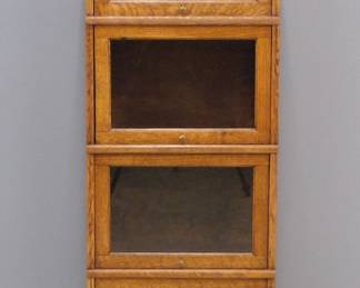 A turn of the century American Barrister's bookcase in the unusual half width.  Oak construction features four stacking sections with glass lift up doors and a molded crown and base.  Refinished with minor wear.  18 x 11 1/2 x 55" high.  