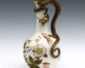 A late 19th century Royal Worcester porcelain ewer retailed by J.E. Caldwell & Co.  Bottle form ewer with applied Dragon handle and enameled Chinoiserie decoration depicting butterflies and flowers on an Ivory White ground.  Printed Green Royal Worcester marks c. 1860s, and "Caldwell Made for Philadelphia".  Several of the Gilded prunts on the Dragon's body with small chips or flakes.  11 1/2" high.   NOTE: From the estate of Bill & Barbara Shulhof of Saginaw, Michigan.