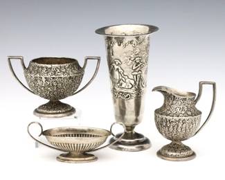 Four 20th century Sterling Silver miniature vessels.  Includes an English  vase with repousse genre scene decoration, an American creamer and open sugar set with vine and berry design, and a Reed & Barton handled bowl with reeded body.  One with English hallmarks, others marked "Sterling".  3.93 troy ozs total.  Some surface wear, vase with some denting.  Up to 3 1/2" high.  NOTE: From the estate of Bill & Barbara Shulhof of Saginaw, Michigan.