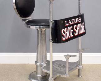 An early 20th century "King Shiner" Ladies shoe shine stand by H. C. Schulse, Inc. N.Y.  Iron construction with polished Nickel finish features an upholstered back and seat and lower footrests with an incorporated adjustable painted iron modesty screen with reads "Ladies Shoe Shine".  Restored with minor paint loss to screen.  28 x 32 x 47 1/2" high overall.  