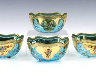 A set of four turn of the century Bohemian Art Glass finger bowls.  Blue glass bowls with ruffled rim and enameled scenic panels of alternating Cherubs and florals with Gilded accents.  Unsigned.  Minor wear to surface and decoration.  5" diameter x 2 1/2" high.   NOTE: From the estate of Bill & Barbara Shulhof of Saginaw, Michigan.