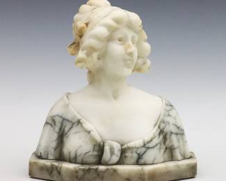 A turn of the century Italian carved Alabaster bust of a young woman wearing a bonnet. Signed "Made in Italy" at back. Minor surface wear, some surface grunge and discoloration. 7 x 7 1/2" high overall.   NOTE: From the estate of Bill & Barbara Shulhof of Saginaw, Michigan.