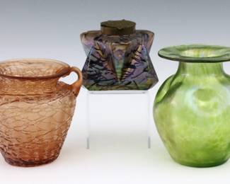 Three pieces of turn of the century Bohemian Art Glass attributed to Loetz and Kralik.  Includes an inkwell with mottled Iridescent Purple and Gold finish, a Green "Creta" bulbous form vase with dimpled body, and a Salmon Pink amphora form vase with threaded decoration.  Each unsigned.  Inkwell with poorly repaired corner, minor losses to threaded decoration, minor surface wear.  Up to 5 1/4" high.   NOTE: From the estate of Bill & Barbara Shulhof of Saginaw, Michigan.