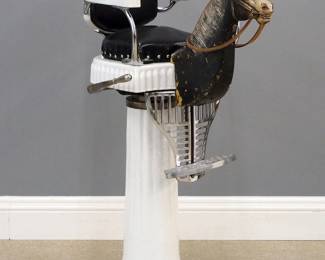 A turn of the century Child's barber chair with Pony.  Cast Iron construction with White porcelain finish features a hydraulic child's size chair with upholstered back and seat, carved wooden pony head with leather rein and painted finish over an adjustable nickeled footrest.  Restored upholstery with minor wear, some wear to  paint.  44 1/2" high.  