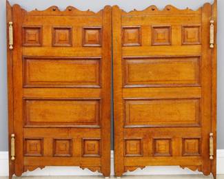 A pair of turn of the century Saloon doors.  Oak construction with multi raised panel design and scrolled top and bottom frames, heavy Brass double swing hinges.  Refinished with minor wear.  Each 28 x 49 1/2" high.  