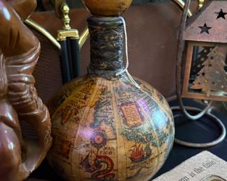 Vintage leather-wrapped green glass decanter featuring an old-world map design.