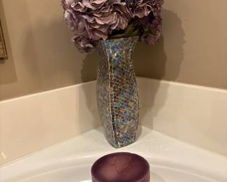 Mosaic multi colored vase and amethyst flowers and candle in front