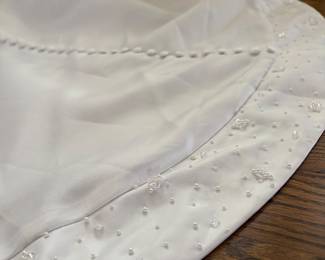 BEADED DETAILING ON TRAIN OF PALLAS ATHENA WEDDING DRESS. NEVER WORN. NEVER ALTERED.