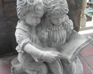 Two children reading concrete figure