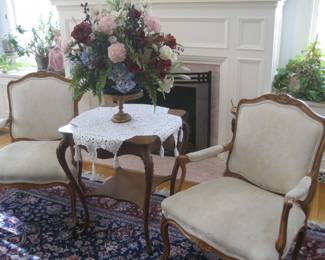 French-style upholstered chairs, antique occasional table, stunning faux floral arrangement