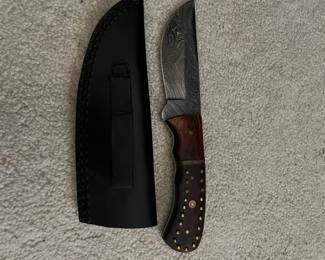 hunting knife with a wood handle and leather sheath