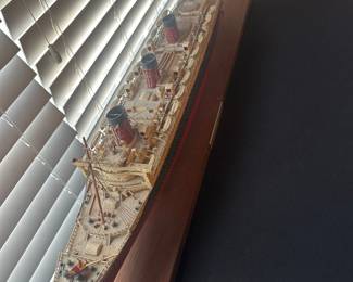 collectible model of an early 20th-century four-funnel ocean liner (H.M.S. Queen Mary)
