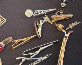 assorted vintage men's accessories, primarily consisting of tie clips, tie bars, and tie tacks